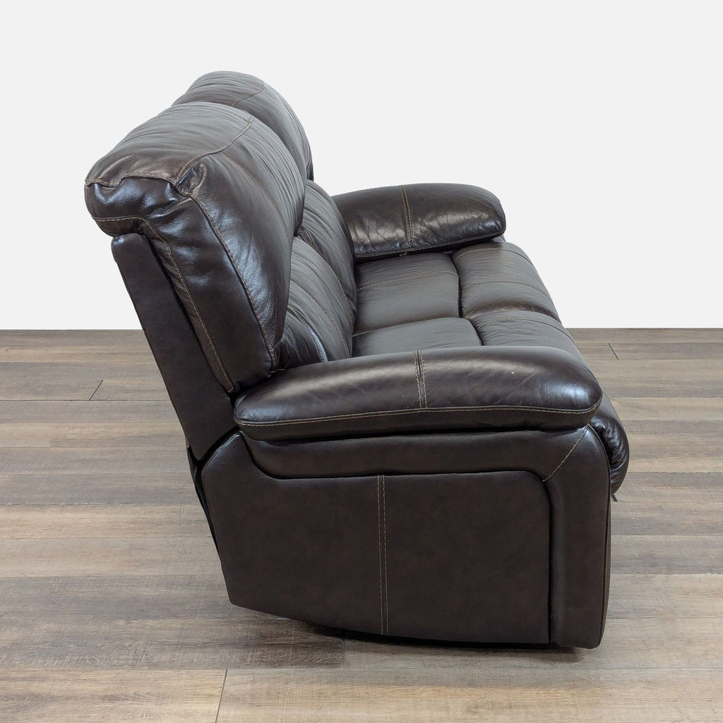 3. Ashley Furniture loveseat seen from the side, featuring manual reclining function and padded leather upholstery.