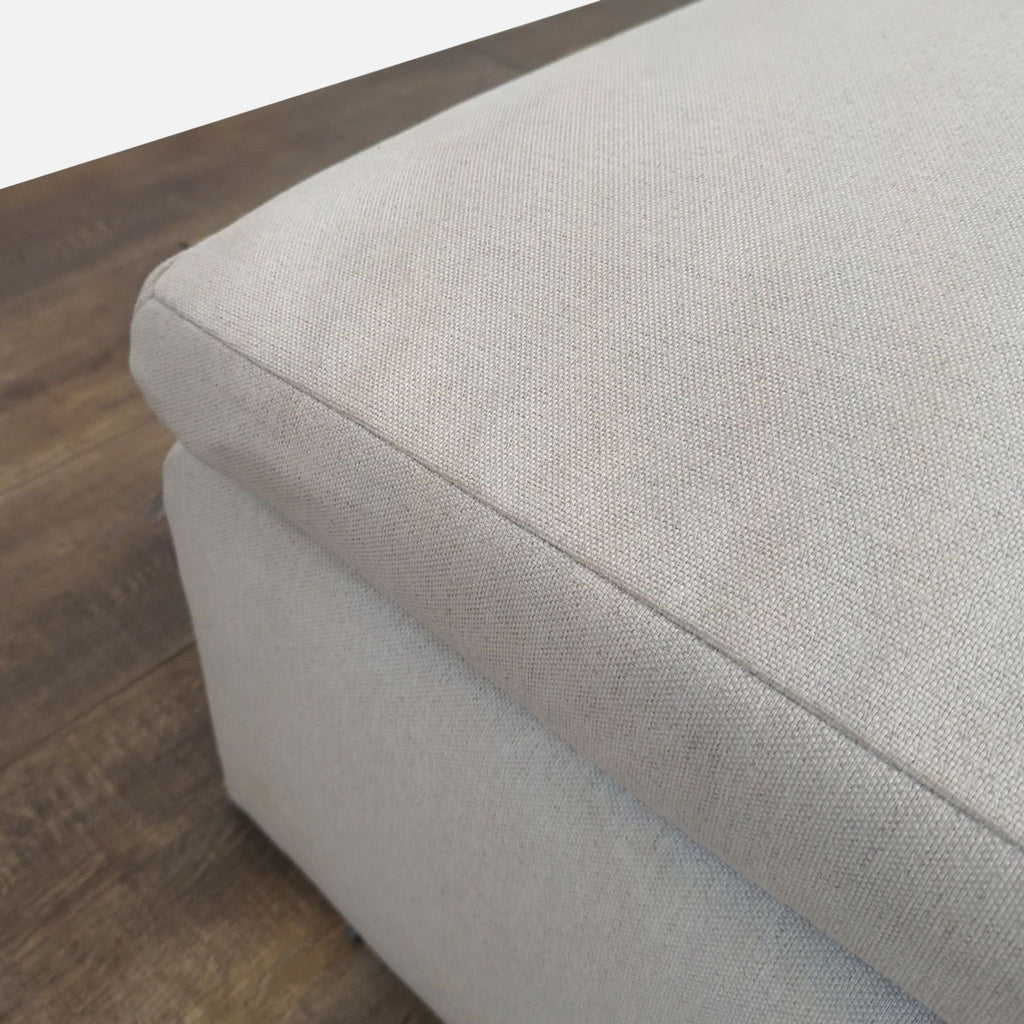 3. Close-up of the textured fabric and stitching on a light-colored Reperch ottoman.