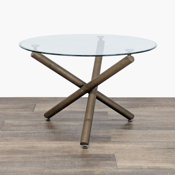 1. Reperch dining table with a round glass top and intersecting metal legs on a wood floor.