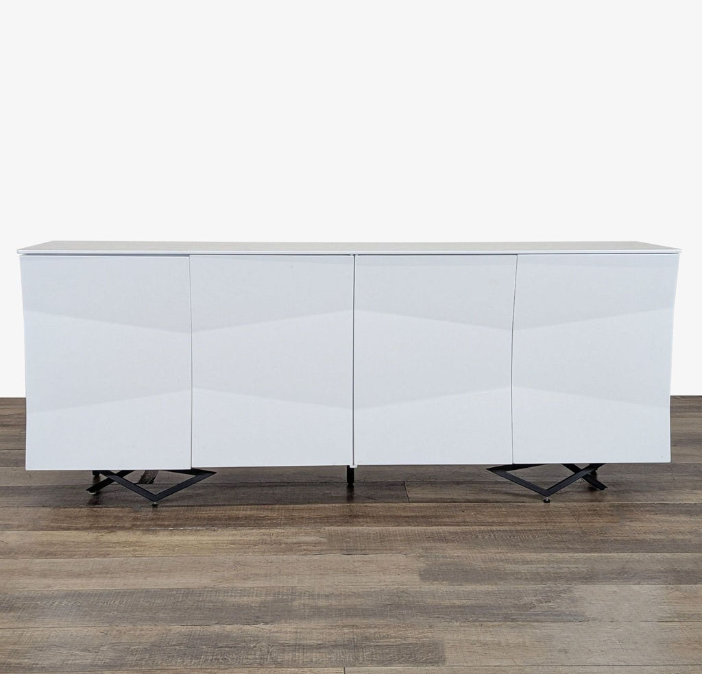1. Front view of a modern white Modrest sideboard with four doors and geometric black legs on wood floor.