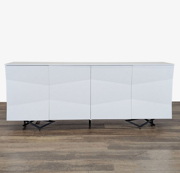 1. Front view of a modern white Modrest sideboard with four doors and geometric black legs on wood floor.