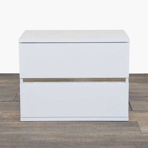 1. Front view of the Status brand end table showing its modern, white rectangular design with two drawers.  