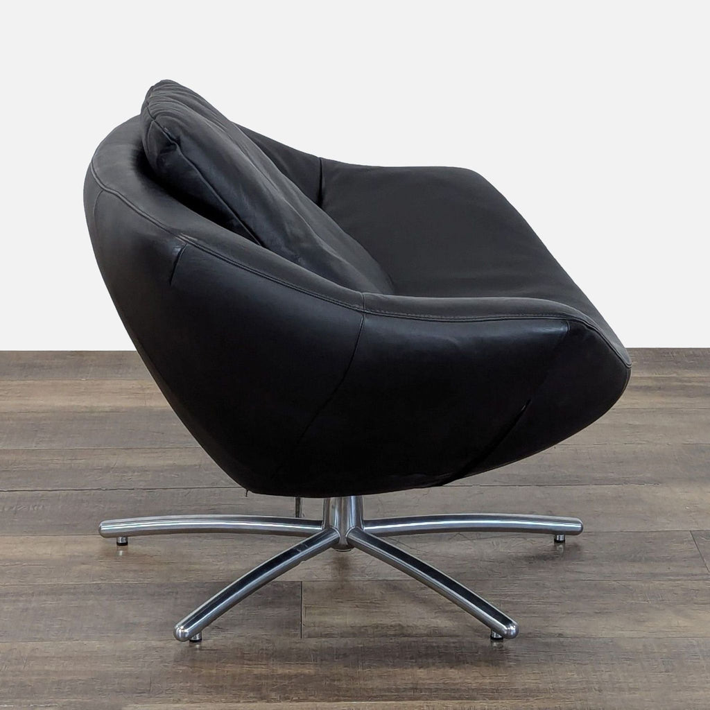 Side view of the GiGi lounge chair, showcasing its shell-shaped black leather seat and 5-point chrome base.