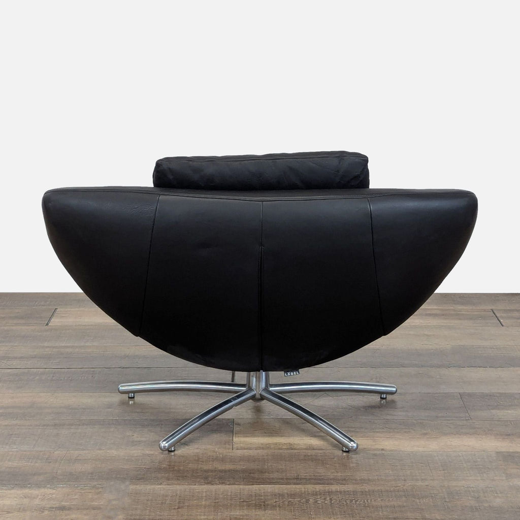 Rear view of the GiGi lounge chair from Label, featuring black Italian leather upholstery and matte chrome swivel base.