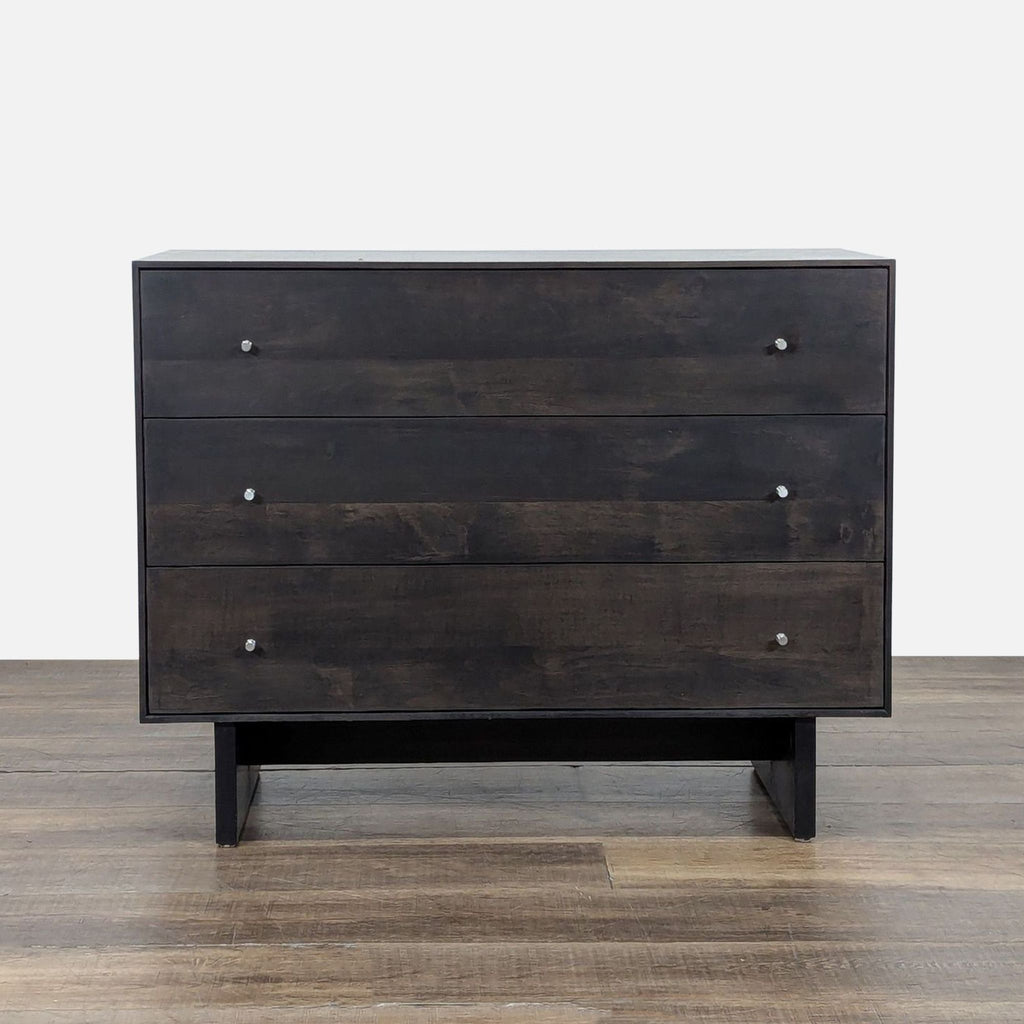 1. Modern charcoal-stained wood dresser with three drawers and metal knobs, by Room and Board, on wood floor.