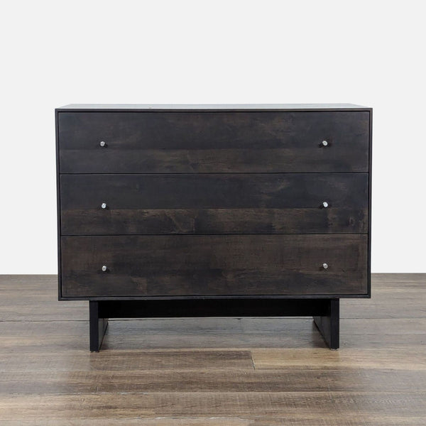 1. Modern charcoal-stained wood dresser with three drawers and metal knobs, by Room and Board, on wood floor.