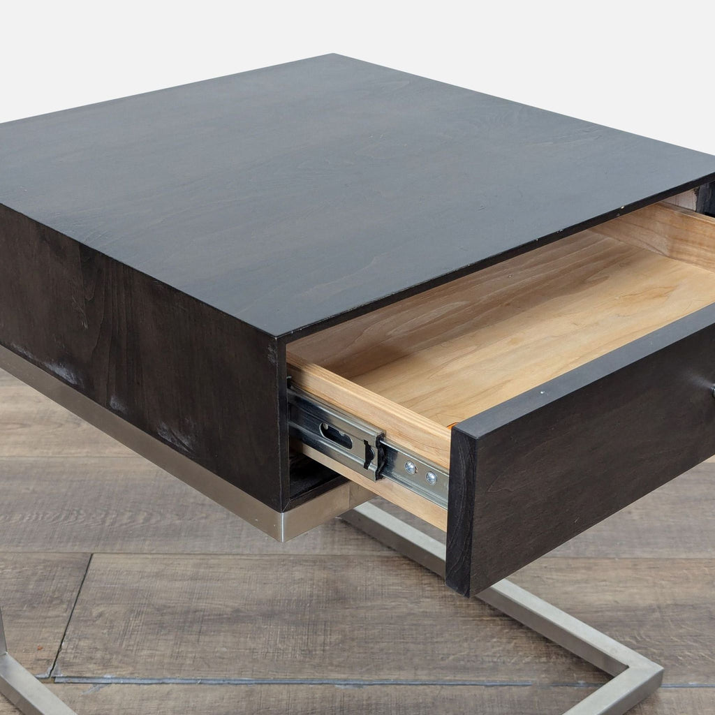 3. Close-up of Room & Board end table revealing wooden interior of the opened drawer and sleek metal base.