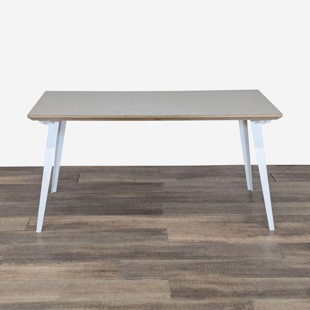 1. Floyd dining table with powder-coated steel legs and birch plywood top, shown from the front on wood flooring.