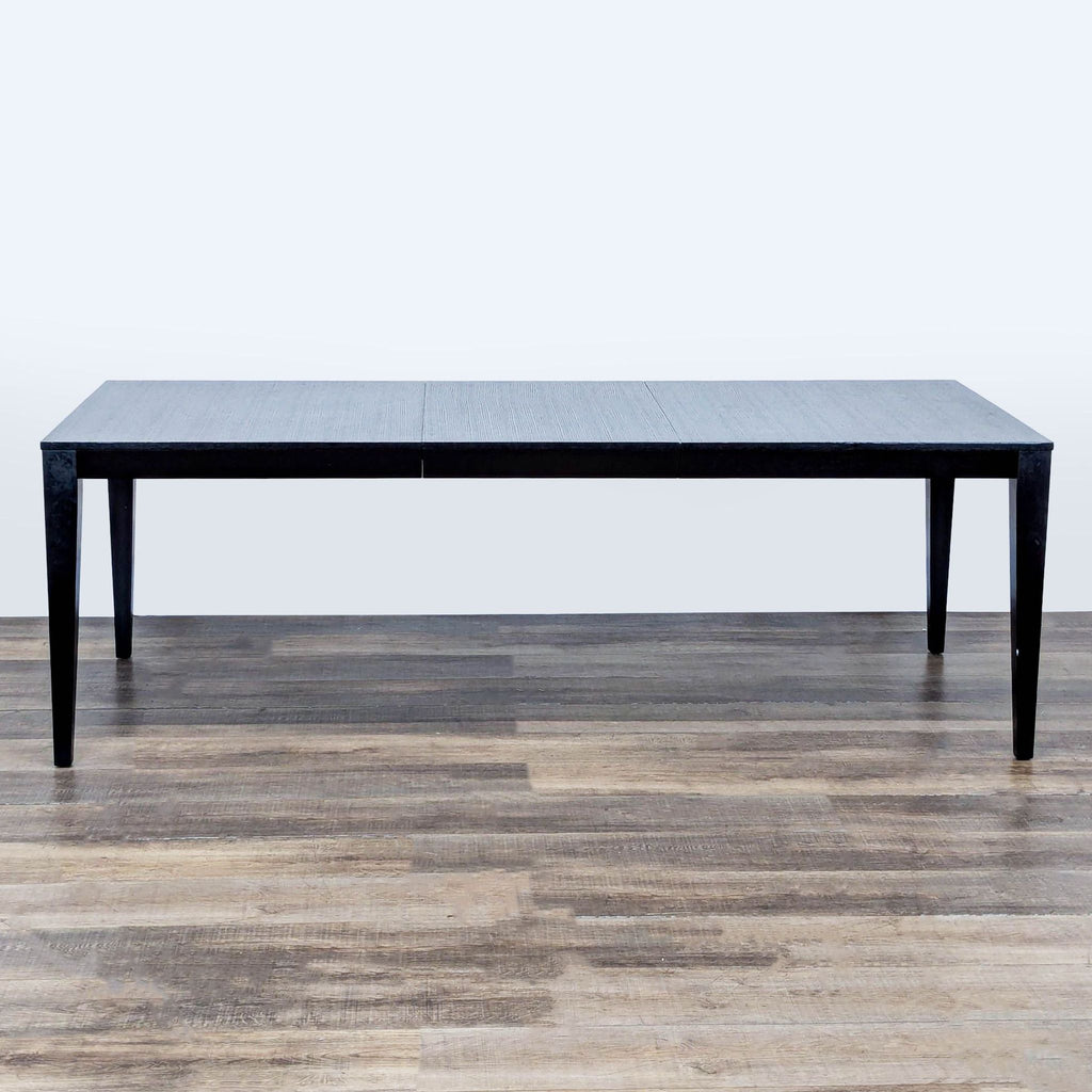 2. Crate & Barrel dining table with solid wood legs, espresso finish, and extendable leaf feature.