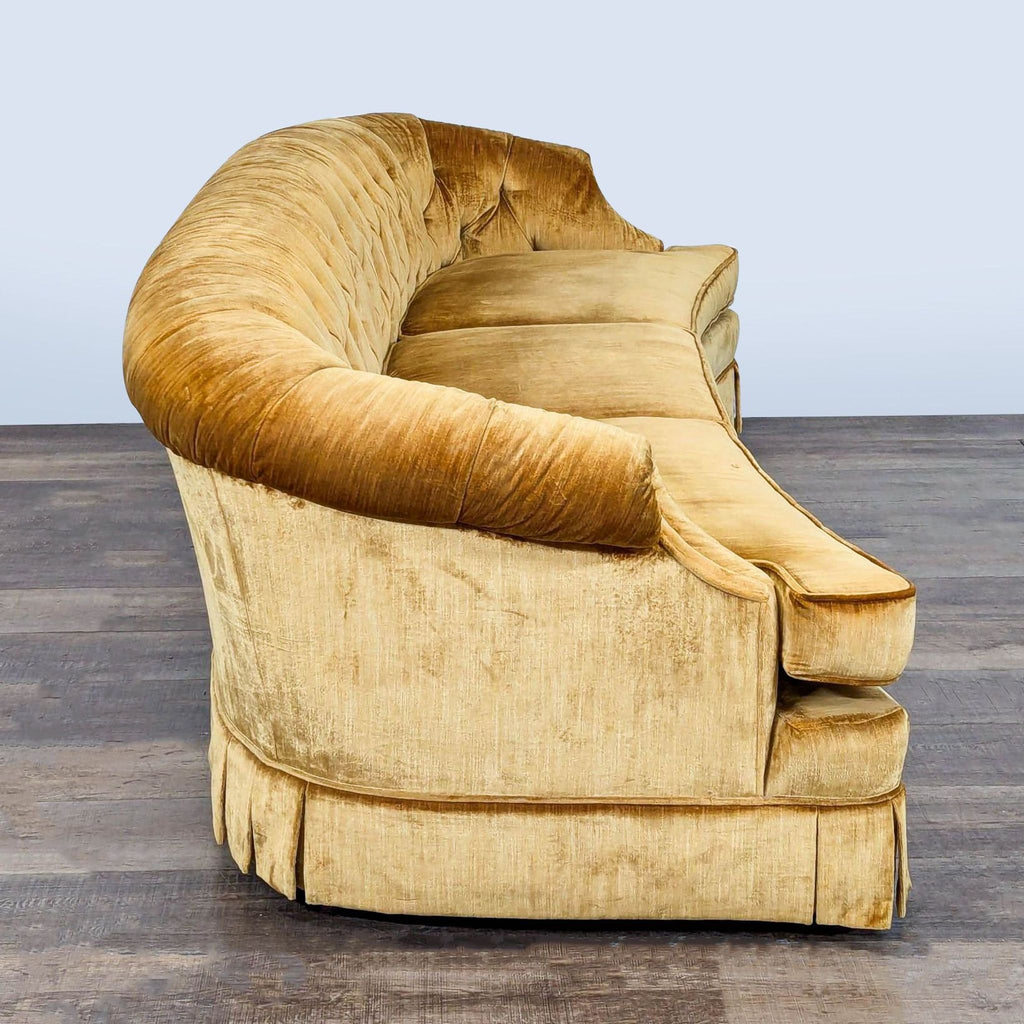 2. Side view of Reperch gold velour 3-seat sofa featuring a tufted back and curved front design.