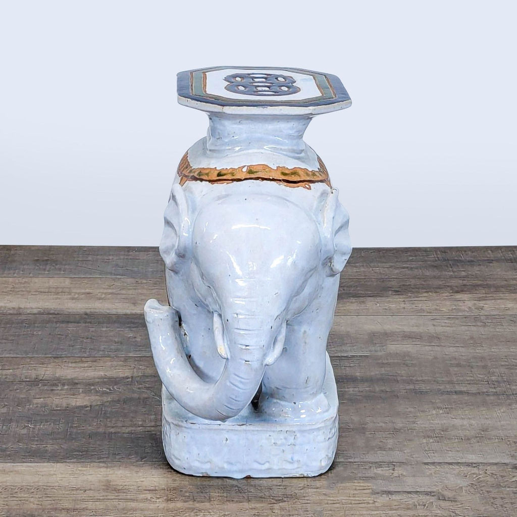 2. Front view of a Reperch elephant-shaped ceramic stool, featuring raised trunk and painted detailing.