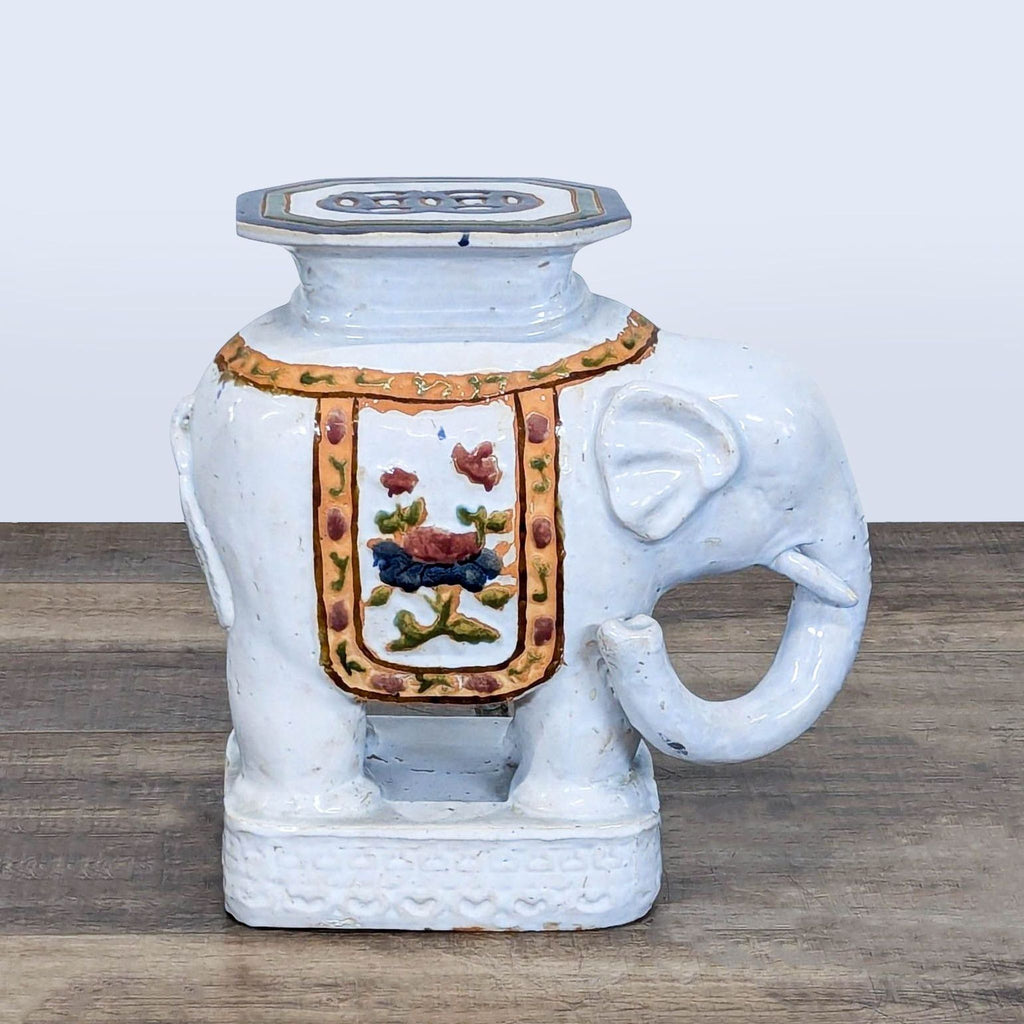 3. Right side of Reperch ceramic elephant stool, decorated with a flower motif and ornate edging.