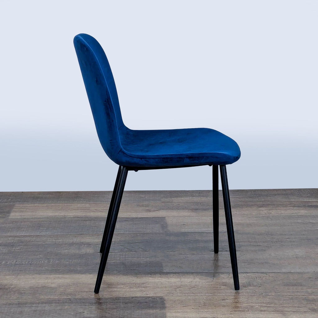 3. Reperch dining chair in blue upholstery with black legs, side profile on a wooden floor.