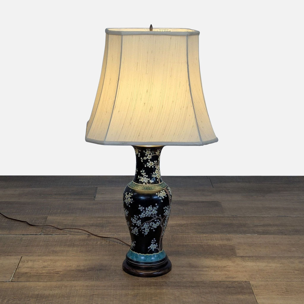 1. Hewitt & Hitchcock table lamp with porcelain floral base and cream fabric lampshade, placed on wood floor.  