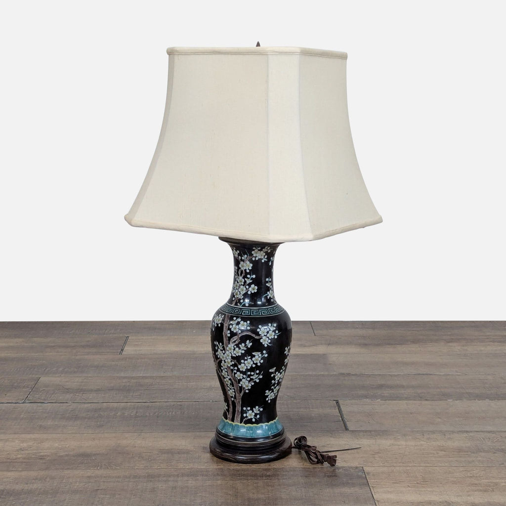 3. Side view of Hewitt & Hitchcock floral porcelain lamp with cream fabric lampshade, cord visible on wood floor.