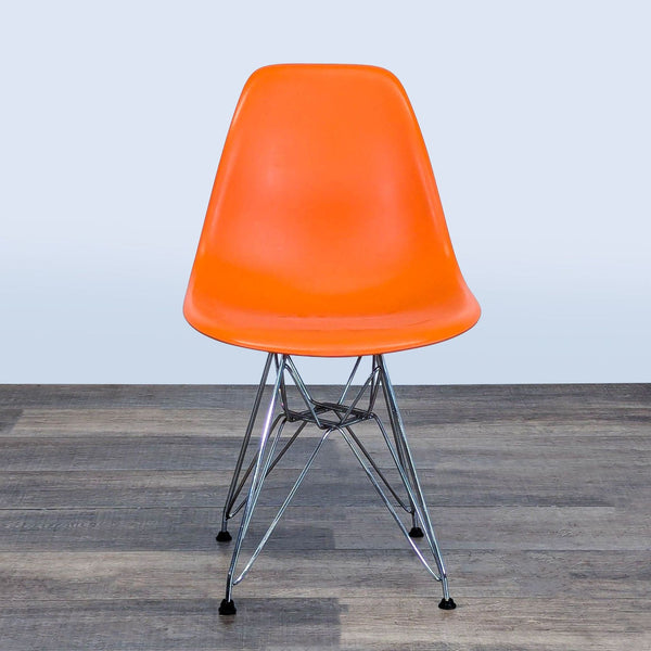 1. Orange molded plastic Belnick dining chair with steel legs, shown from the front on wooden flooring.