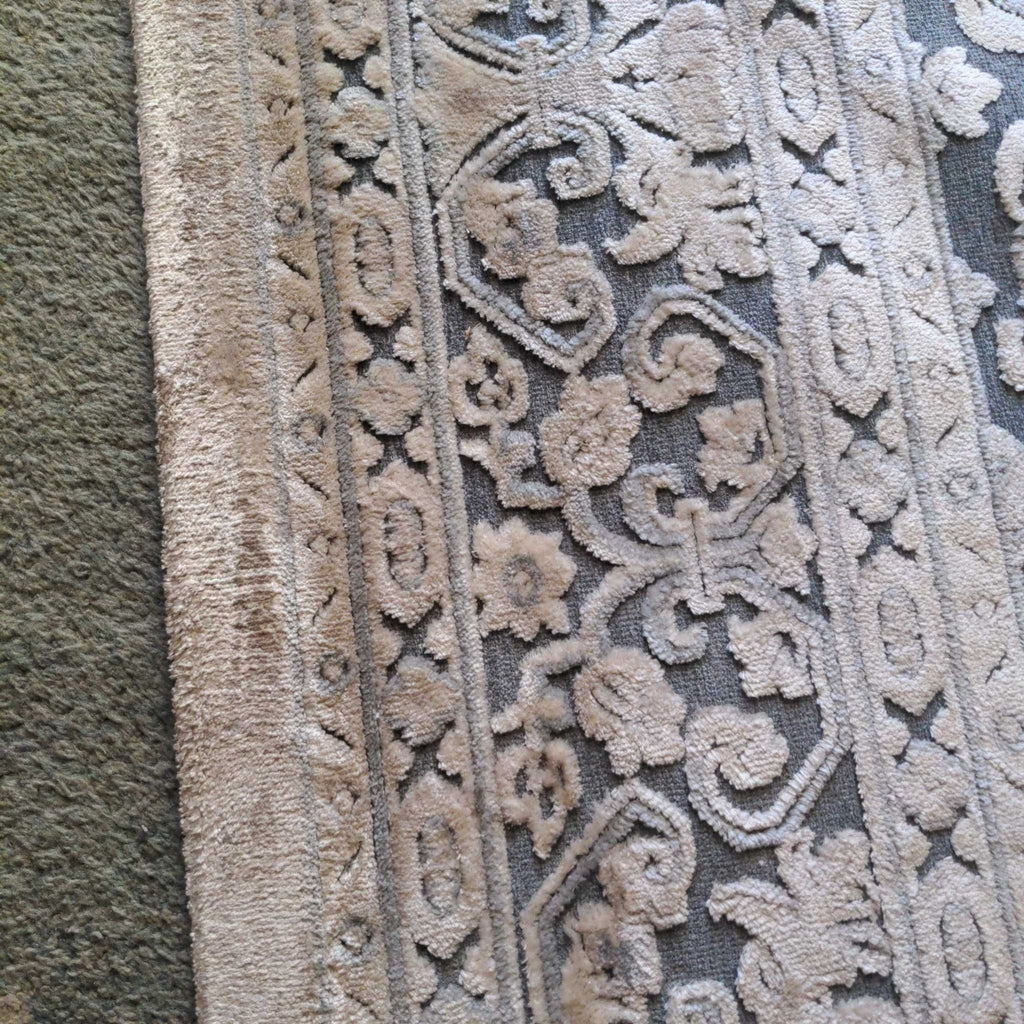 2. Close-up of the Jaipur rug shows intricate raised damask and floral designs in a rayon and acrylic blend.