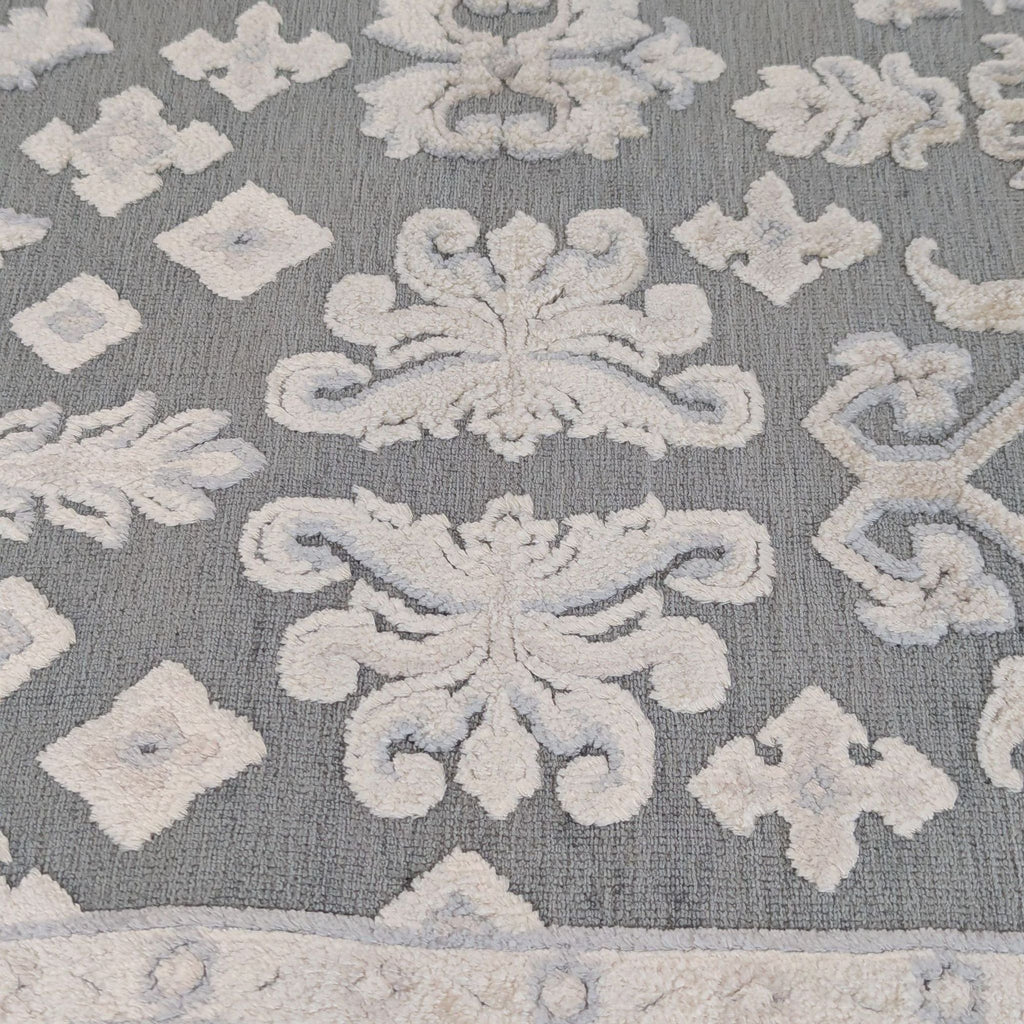 3. Detailed view of the Jaipur rug’s textured surface, highlighting the high-low damask pattern in soft shades.