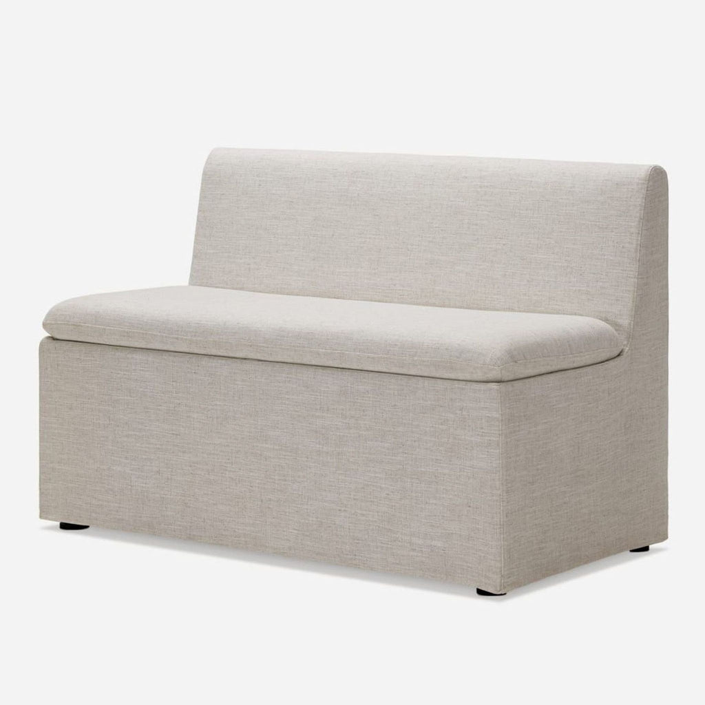 2. Angled view of a Castlery engineered wood bench with melamine finish and plastic legs, upholstered in beige.  