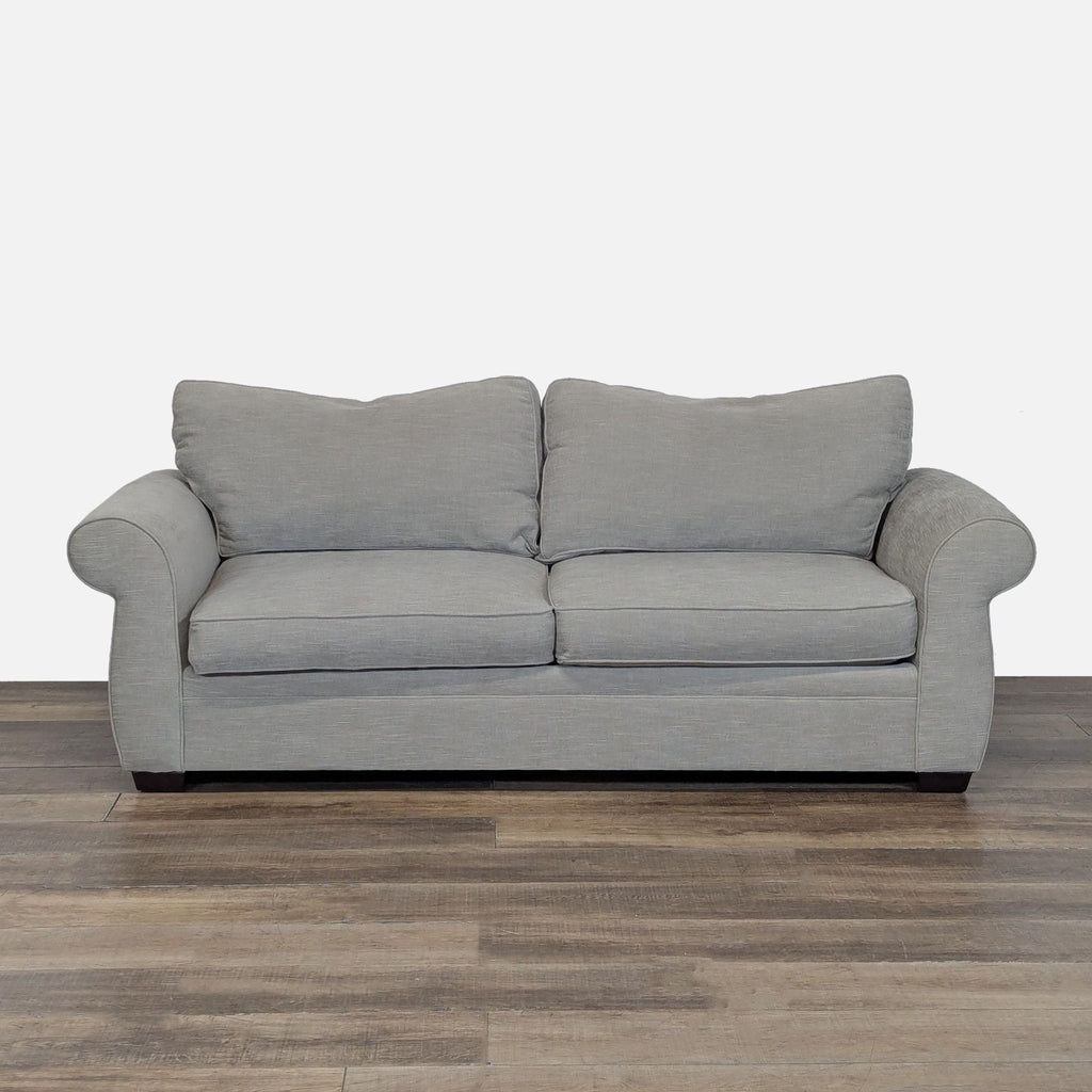 1. Front view of a Pottery Barn loveseat with rolled arms, wood feet, and light gray tweed upholstery.