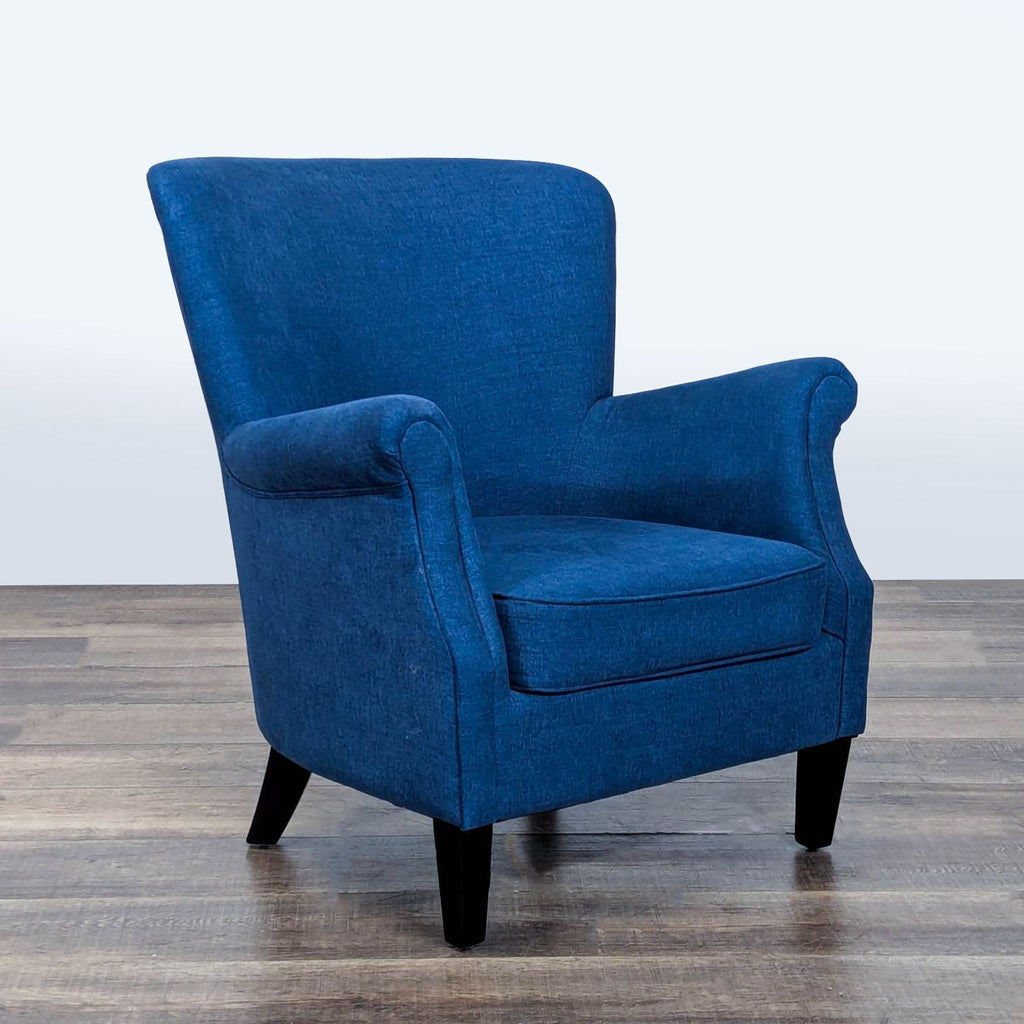 3. Angled view of a heathered blue Pottery Barn lounge chair with wood legs and classic rolled arms.