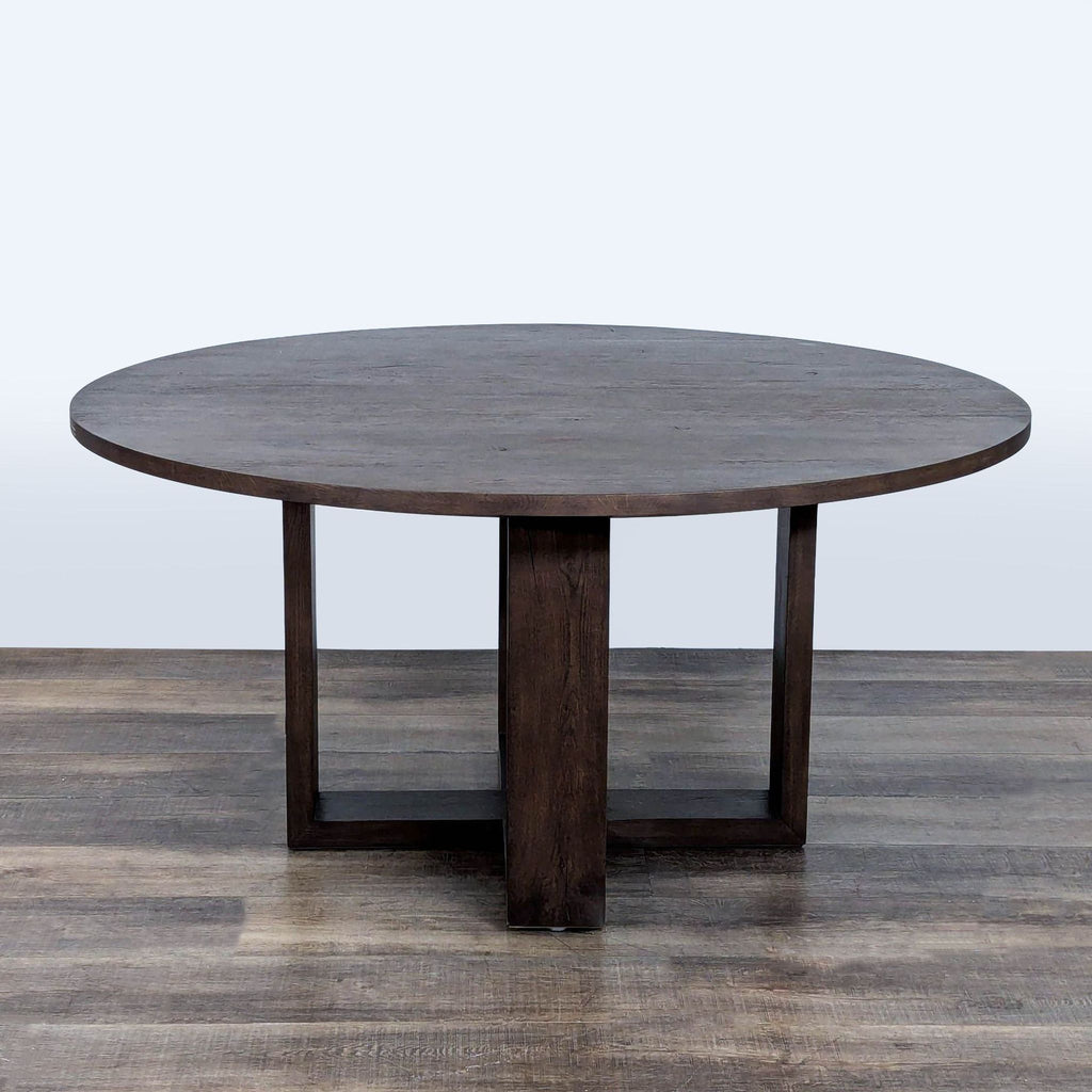 2. Contemporary dark wood round dining table from Restoration Hardware featuring a sturdy geometric base.