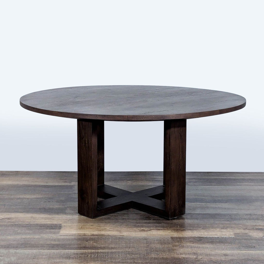 3. Restoration Hardware dining table, round design in rich wood with intersecting square legs for support.