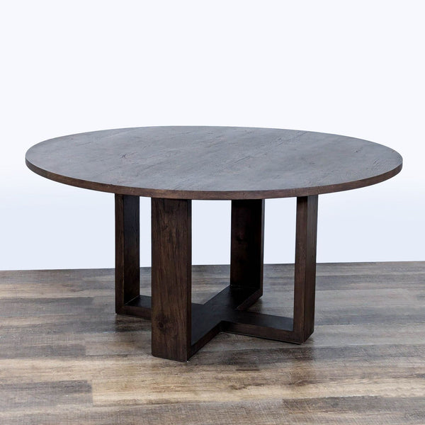 1. Restoration Hardware round dining table with dark wood finish and modern, cross-shaped pedestal base.