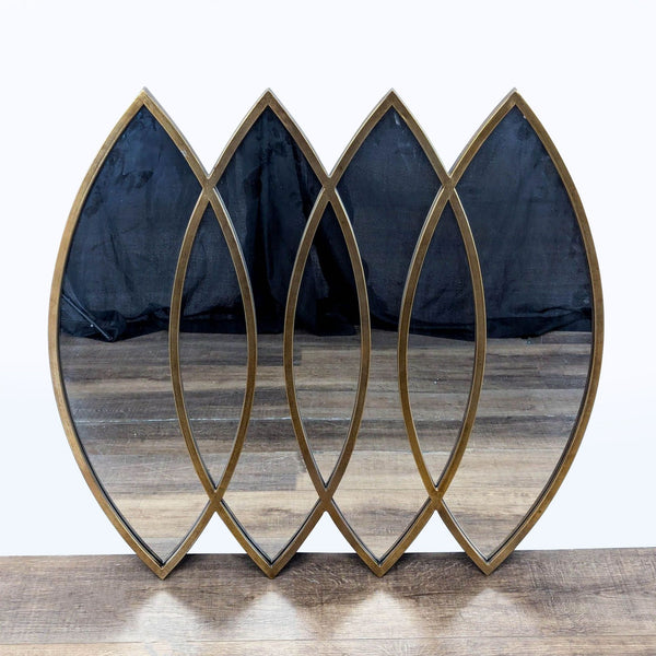 1. Decorative Reperch mirror with four overlapping leaf-shaped panels and a gold-toned frame on wooden floor.  