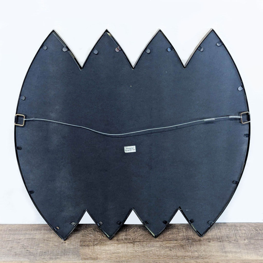 2. Rear view of the Reperch mirror shows a black backing, triangular points, and attached hanging wire.