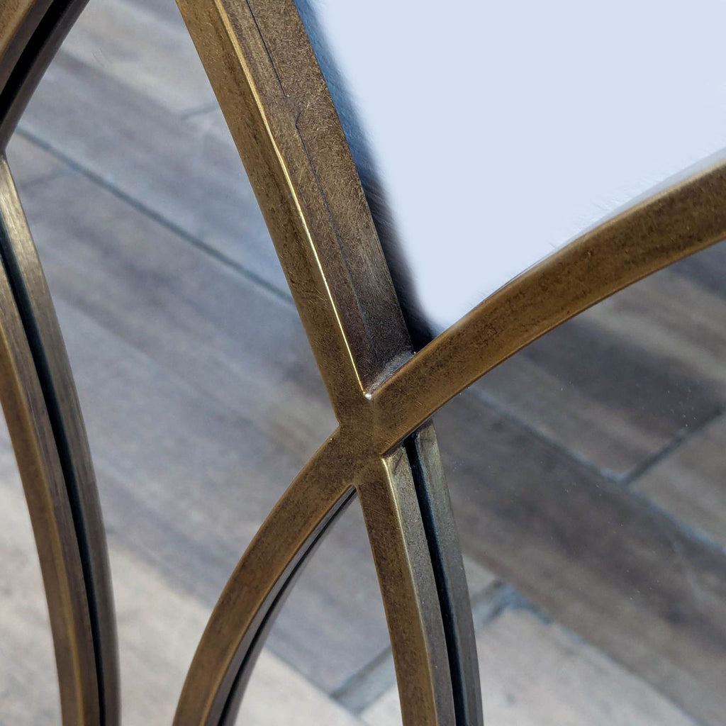 3. Close-up of the intersecting gold-toned frame of the Reperch mirror, highlighting its detailed finish.