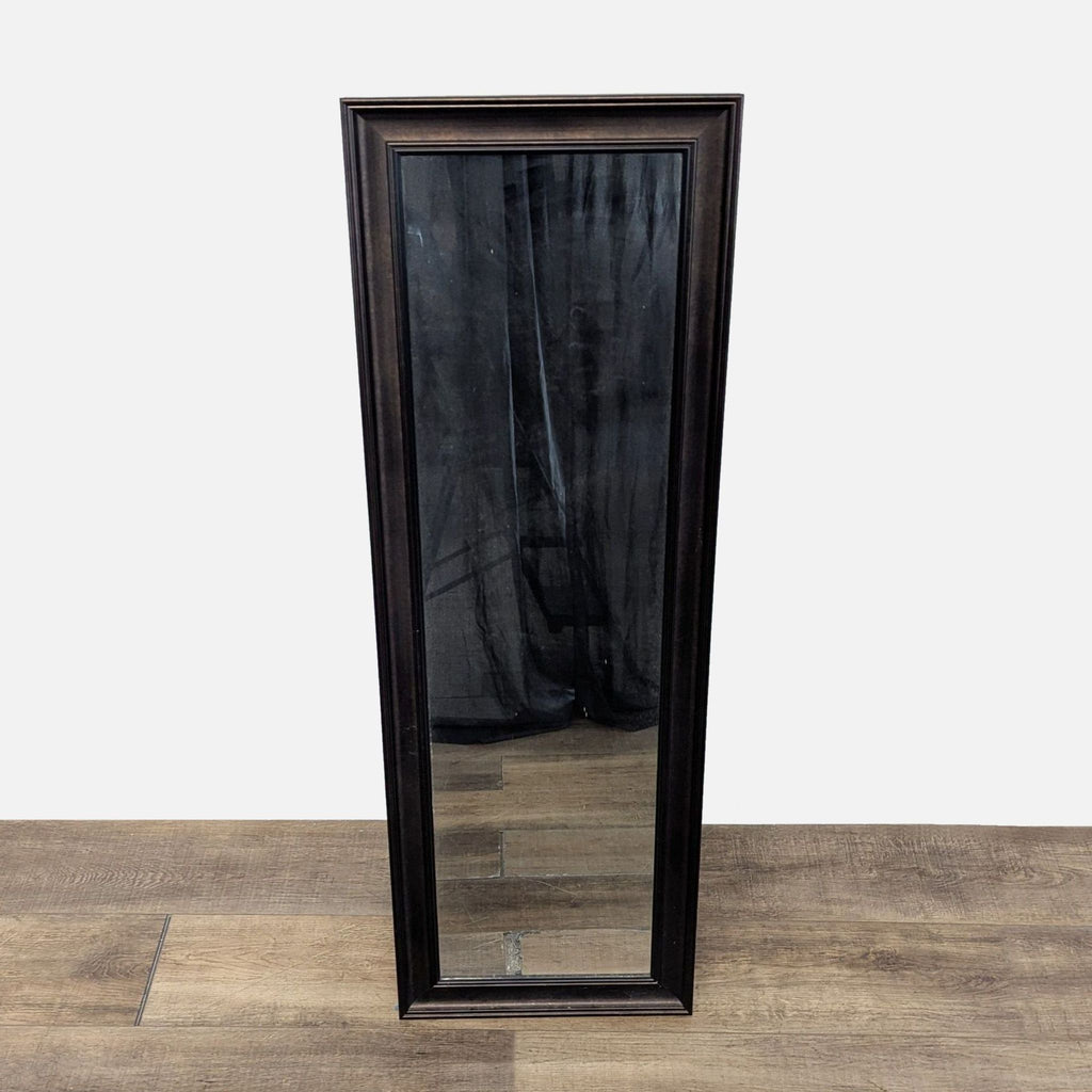 Full-length rectangular mirror with a dark brown frame from Target, standing on a wooden floor.  