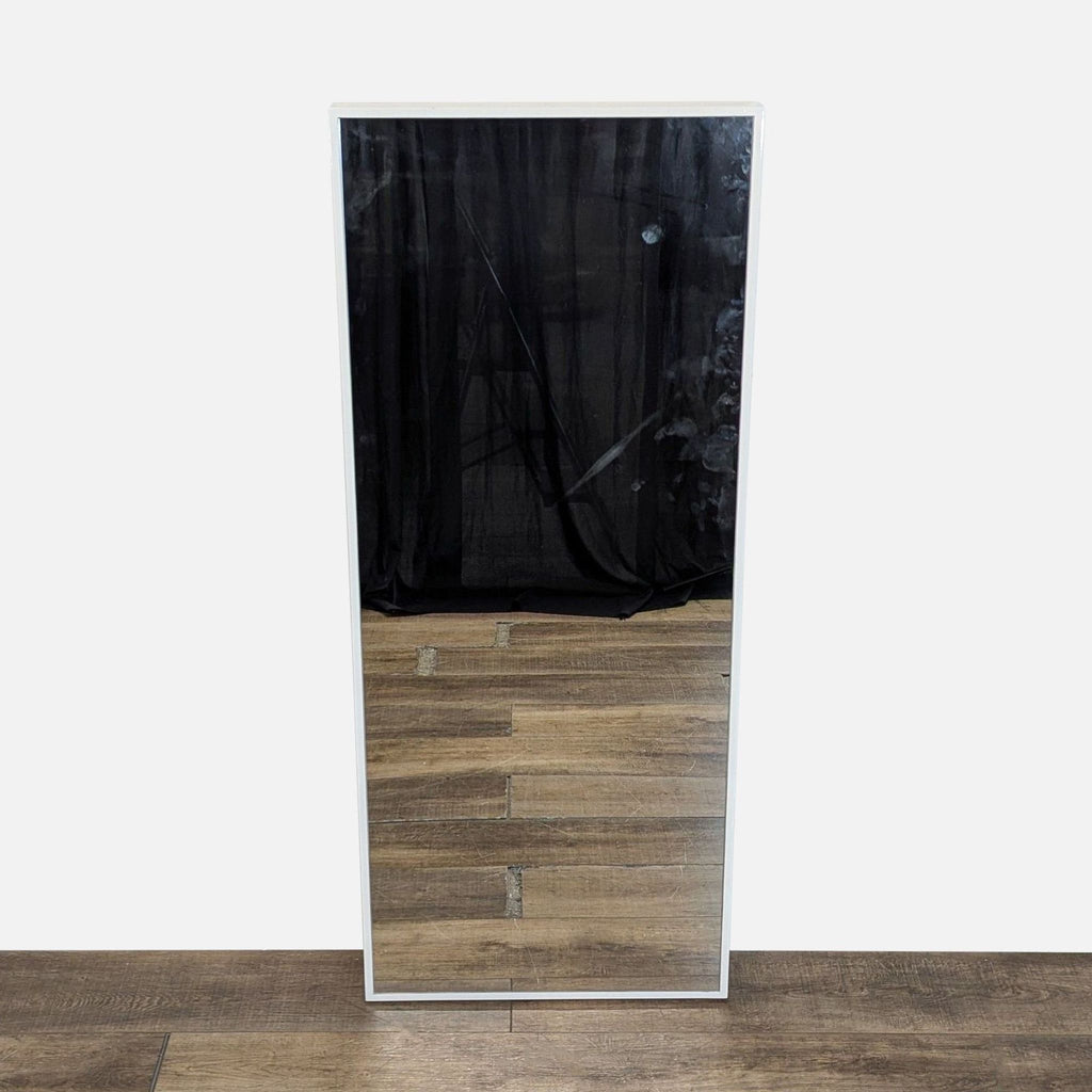 1. Rectangular Reperch mirror with white frame, standing on a wood floor, reflecting dark curtains.