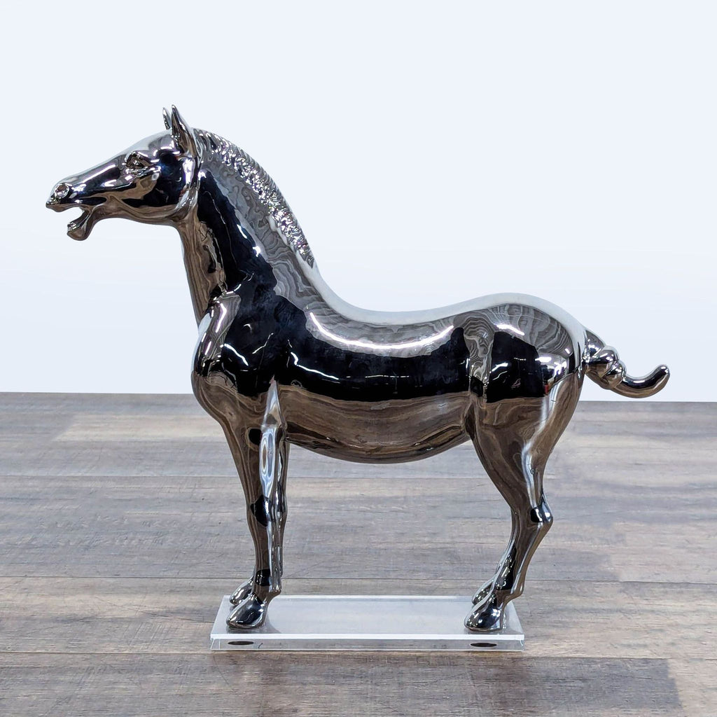 1. Mirrored chrome horse sculpture on clear acrylic base, modern West Elm decor piece on wood surface.