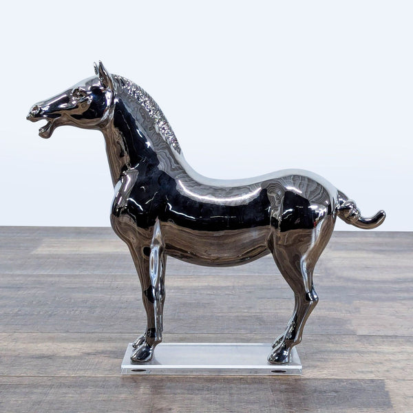 1. Mirrored chrome horse sculpture on clear acrylic base, modern West Elm decor piece on wood surface.