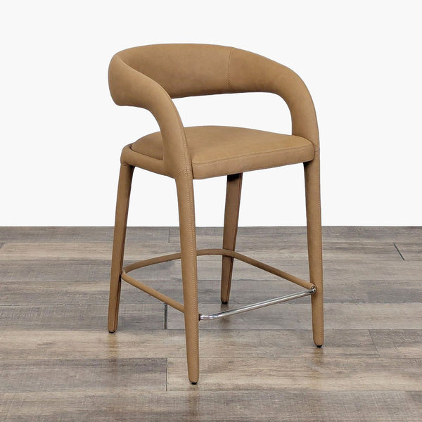1. Tan vegan leather stool with cantilevered backrest and curved arms, shown on a wooden floor, angled view.