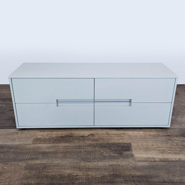 1. CB2 Latitude Low Dresser with four hardware-less drawers and a glossy white finish on a wood floor.