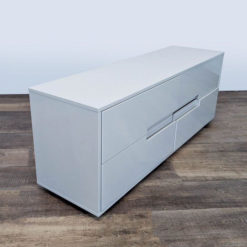 2. Side view of modern CB2 four-drawer dresser, featuring hi-gloss white finish and seamless drawer design.