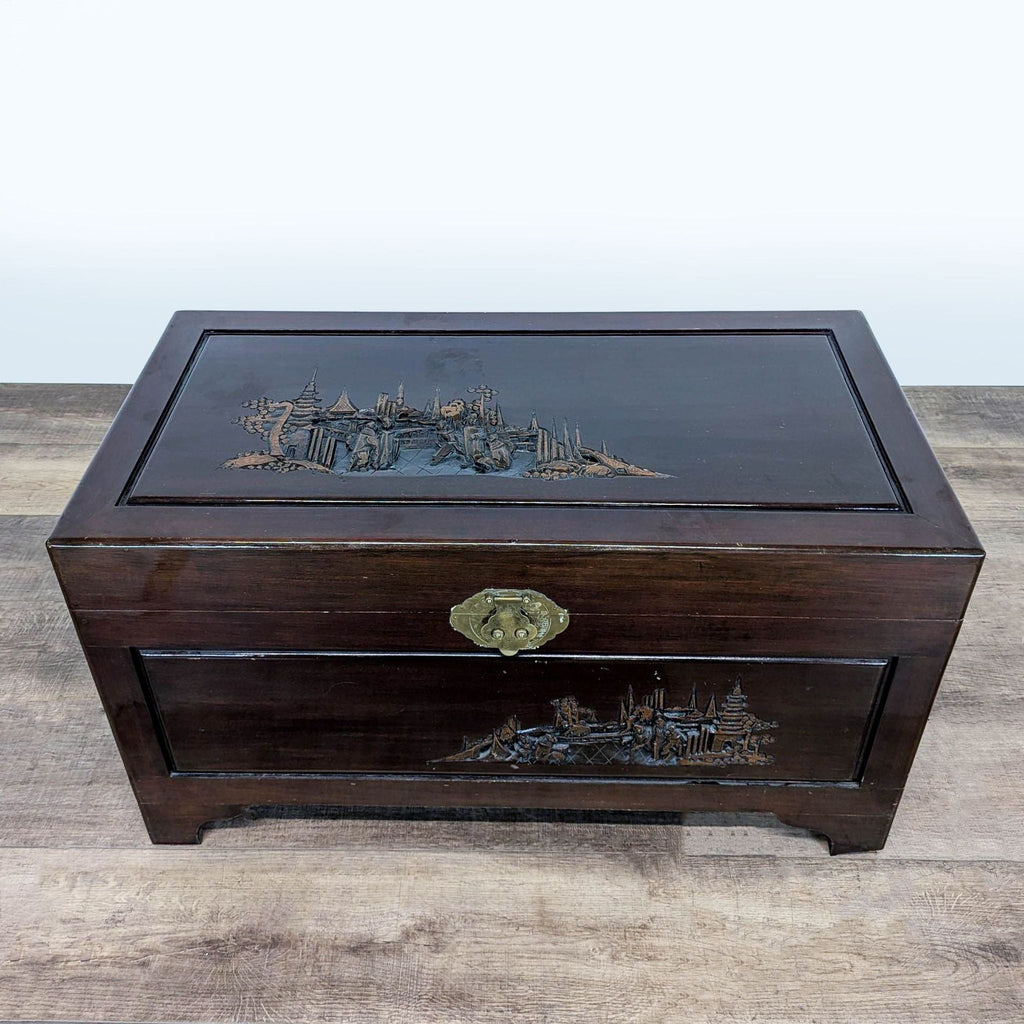 3. Top view of a Reperch trunk, highlighting engraved landscape artwork and decorative metal latch.