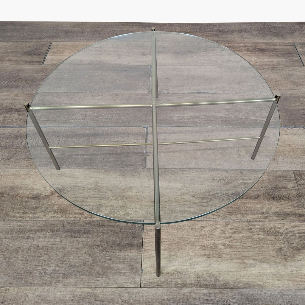 3. Overhead view of Reperch round coffee table with a transparent glass top and thin metal legs.