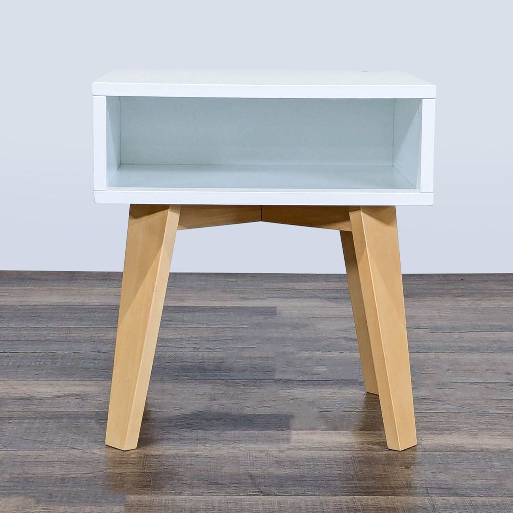 1. Modern Crate & Barrel Kids end table with a white open shelf and light wood angled legs, front view.
