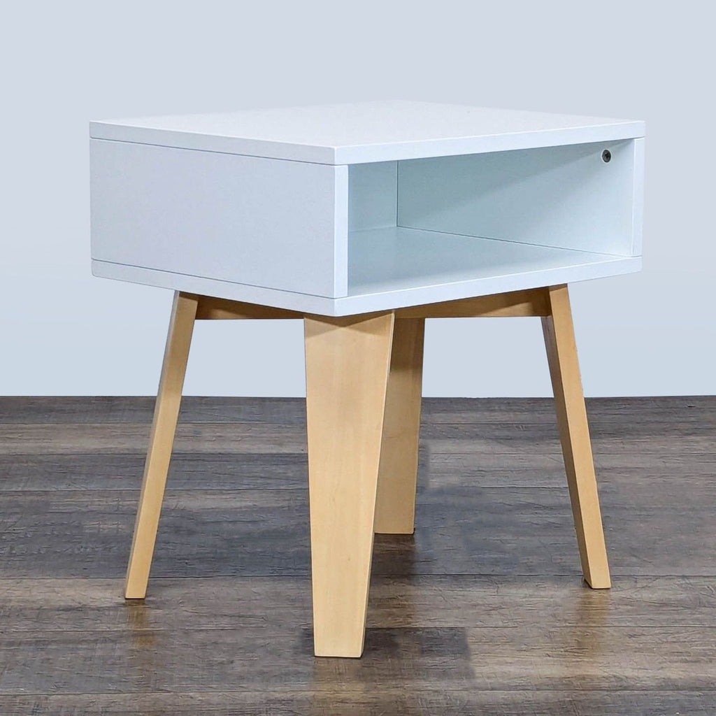 2. Side angle of a Crate & Barrel Kids end table featuring a white box shelf and natural wood legs.