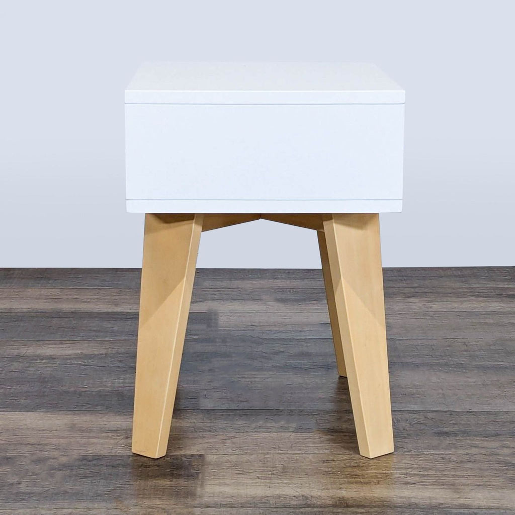 3. Crate & Barrel Kids end table, white rectangular top with open front and four angled natural wood legs, side view.