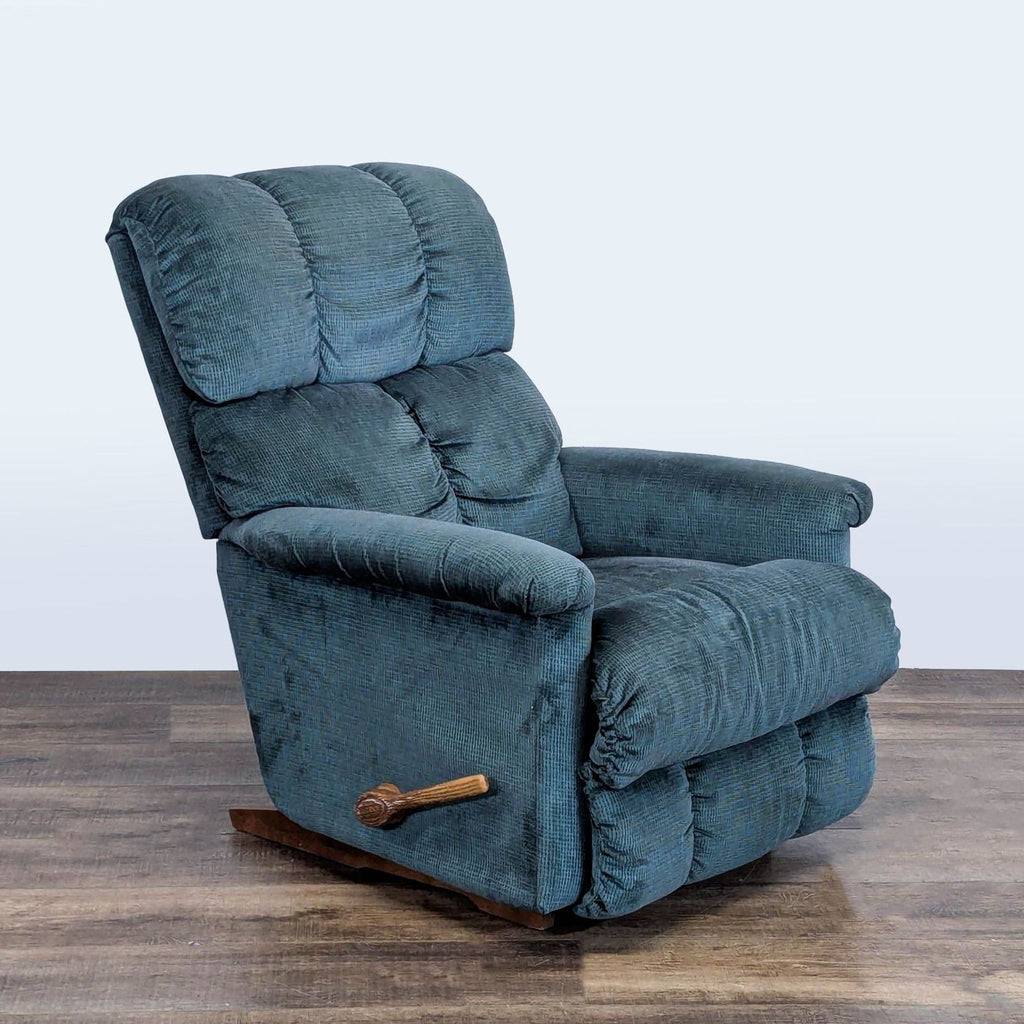 3. Angled side view of a blue upholstered La-Z-Boy manual lounge recliner with visible lever.