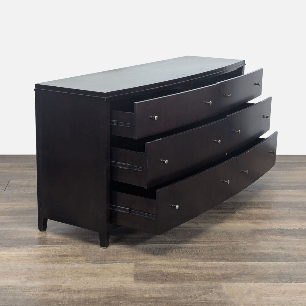 2. Angled view of a Reperch bowed front dresser showing six open drawers with metal glides.