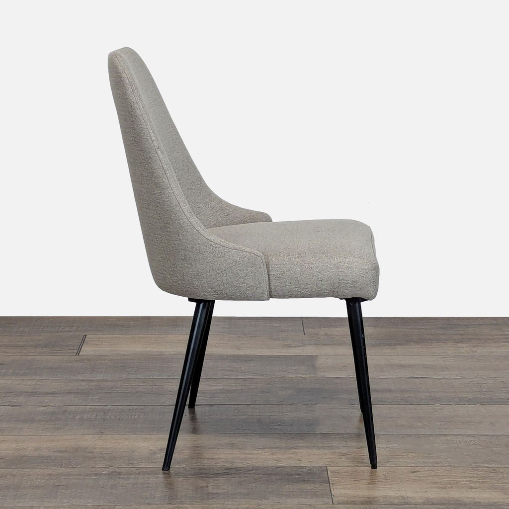 2. Side profile of a Reperch dining chair, showing its supportive curved backrest and cushioned seat with black legs.  