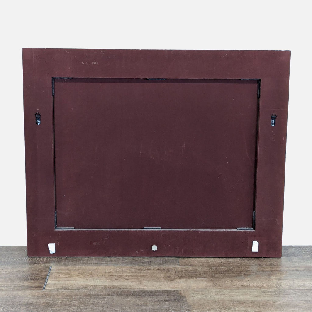 2. Back view of a Reperch mirror showing solid brown backing with wall mounting hardware on the sides.