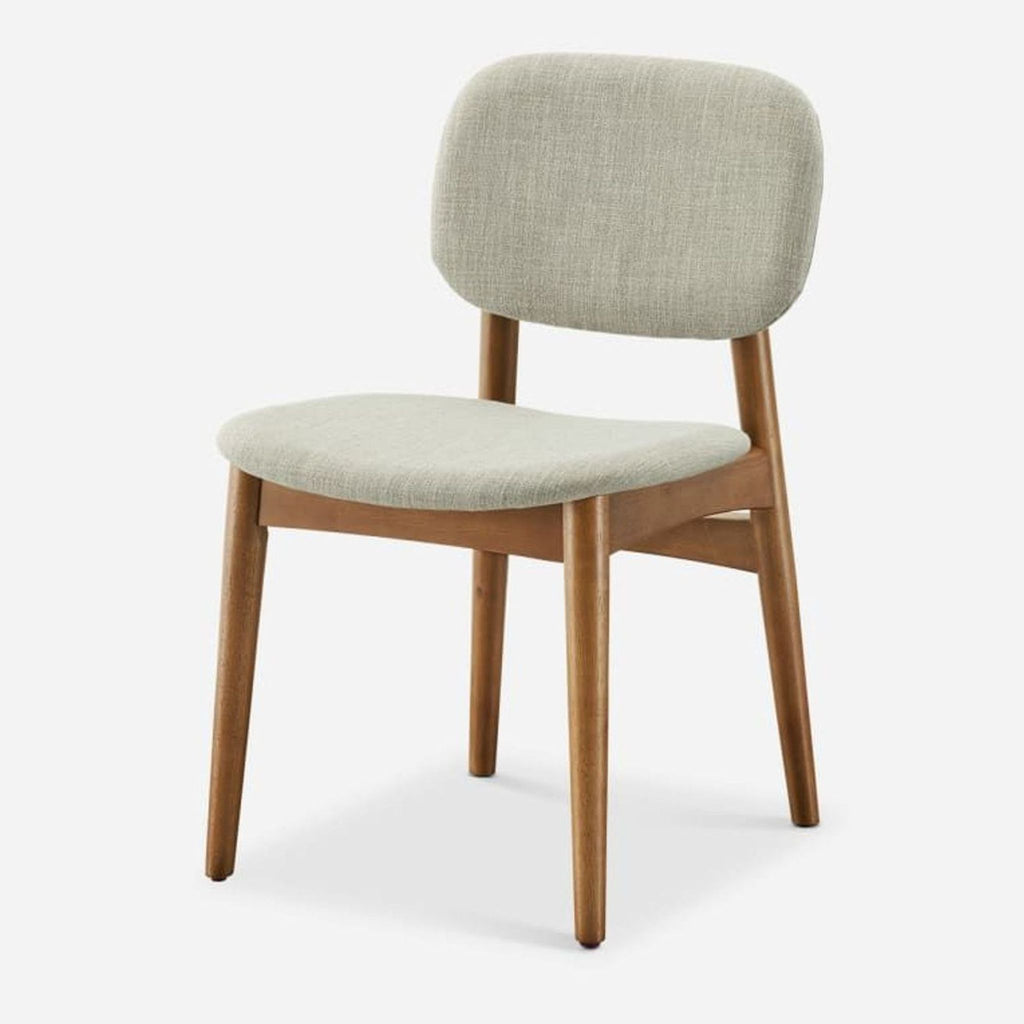 3. Angled view of a single Castlery dining chair featuring fabric upholstery on bent wood seat and rubber wood legs.