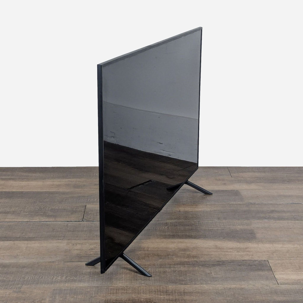 3. Side view of the slim Samsung 65-inch TV, emphasizing its thin profile and modern TV stand.