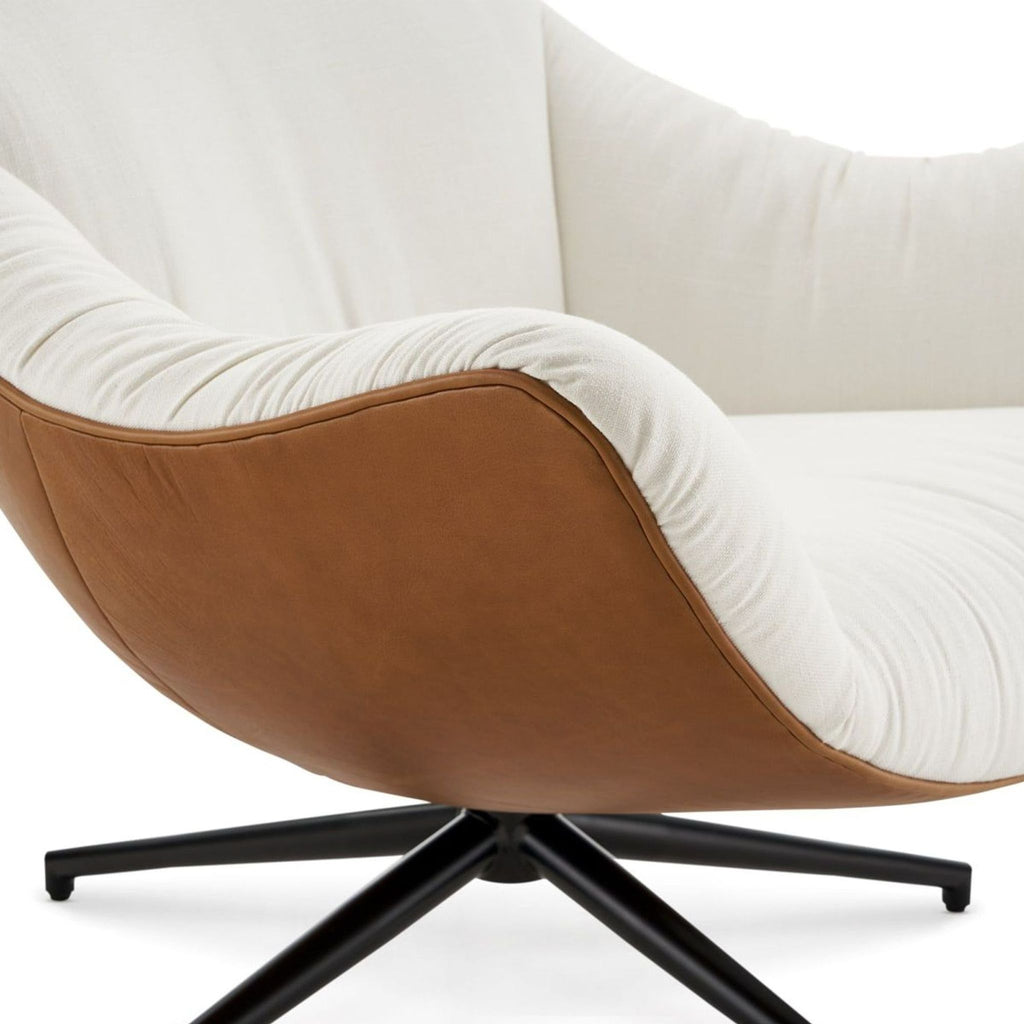 3. Close-up of the Arden lounge armchair’s curved design, showing off its soft cream fabric and brown back upholstery.